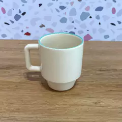 Caneca Elo - Araçá marca Oxford. A caneca é vista de frente e possui um tom off White e a borda na cor menta. Seu formato é mais bojudo e moderno. Perfeita para que gosta de peças mais modernas, pausas para cafés afetivos e momentos tranquilos em casa.