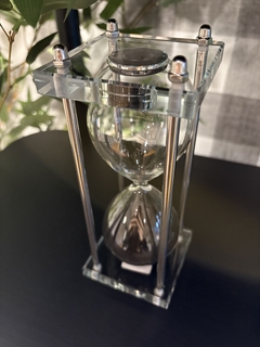 Ampulheta vidro e pó preto com estrutura na internet