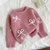 Sweater rosa con moños en internet