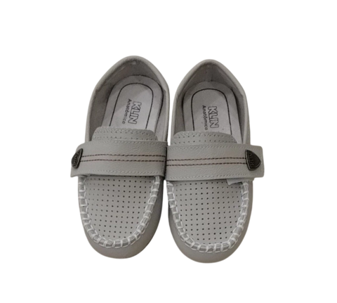 Imagem de um par de sapatos Klin em tom marfim, com detalhes de costura branca e tira de velcro na parte superior.