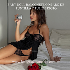 Modelo luciendo un baby doll balconete negro con aro de puntilla y tul, posando con una cámara.