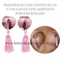 Pezoneras en forma de corazón con lentejuelas rosadas y colgantes de flecos, presentadas en un fondo claro.