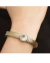 Bracelete em metal prata com pedra rivoli cristal, adornando um pulso humano.