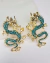 "Brinco Drago em metal dourado com design de dragão e aplicação de strass verde, estiloso e de inspiração oriental"