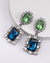 Brincos elegantes com pedras verdes e azuis, adornados com strass brilhantes. brinco da serie bridgerton 