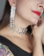 " Brinco Have Fun: Acrílico prateado com strass e franjas brilhantes, perfeito para adicionar um toque de glamour ao seu look."