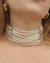 Colar choker prateado com 11 camadas de mini pérolas, usado por uma mulher.