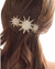 Pente prateado com estrelas brilhantes preso em cabelo castanho