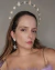 Mulher usando tiara dourada com estrelas e brincos combinando, ideal para o Carnaval.