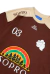 Camiseta Rolimã Racing Marrom com estampa arco iris e detalhes em bege da marca "SOPRO"