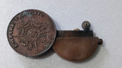 Isqueiro em forma de moeda com figura de Napoleão III na internet