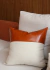 Almofada Premium Collection em couro caramelo e linhão, com design moderno e elegante, posicionada sobre um sofá claro.