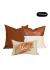 Kit de três almofadas decorativas com design de folhas, nas cores cobre e marrom.