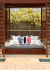 Almofada impermeável coral azul marinho quadrada em um ambiente externo relaxante, rodeada por outras almofadas decorativas com temas náuticos.