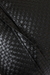 Close-up de uma almofada de couro tramado em preto, perfeita para decoração de ambientes elegantes.