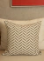 Almofada quadrada com estampa Chevron em tons de cinza e branco, destacando-se em um sofá claro.