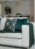 Conjunto de três almofadas Brunello em verde musgo, decorando um sofá claro, com uma manta verde ao lado.