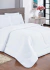 Edredom branco de 230 fios sobre uma cama, com travesseiros brancos e decoração minimalista ao fundo.
