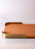 Bandeja de couro em tom laranja com detalhes em metal dourado, ideal para decoração de interiores.