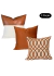 Kit de almofadas cobre e offwhite com três peças, incluindo almofada de couro e estampas decorativas.