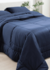 Edredom azul marinho de 230 fios sobre uma cama com travesseiros na mesma cor.