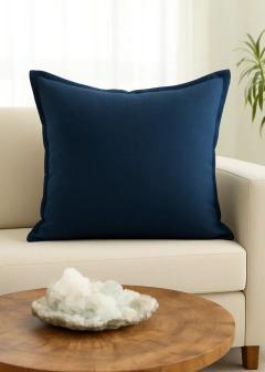 Almofada quadrada azul marinho em linho tramado com abas, 60x60 cm, sobre sofá claro em ambiente decorado