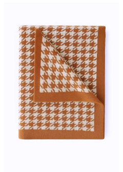 Manta tricotada com estampa pied-de-poule nas cores sisal e bege, dobrada em fundo branco