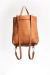 Mochila de cuero full grain sin forrería. Puede convertirse en bolso para llevar al hombro intercambiando la posición de las correas.

Tiene un bolsillo interno y otro externo en la espalda con cierre metálico.