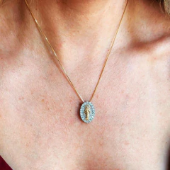 Colar religioso Nossa Senhora das Graças Duo com medalha oval dourada e detalhes em pedras, usado no pescoço de uma pessoa