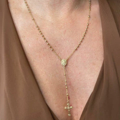 Colar terço dourado com medalha de Nossa Senhora das Graças e crucifixo usado no pescoço de uma pessoa