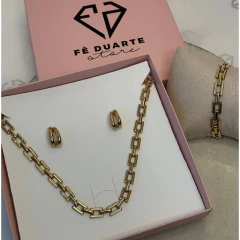 Conjunto de joias MIX Elos Impulse Trio com colar, brincos e pulseira dourados em caixa rosa da Fê Duarte Store