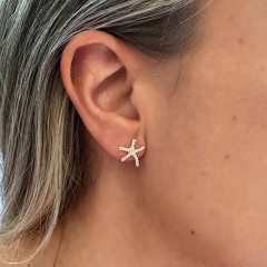 Brinco pequeno em formato de estrela do mar na orelha de mulher, em ouro