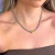 Colar Riviera Spike Triângulo em ródio branco com detalhe em citrino, usado por uma mulher.