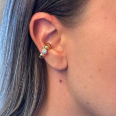 Piercing New Balls Ouro com esferas douradas e uma esfera cravejada de zircônias cristais na orelha feminina