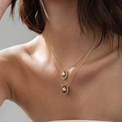 Colar escapulário duplo em ouro com pingentes em formato de Sagrado Coração, usado por mulher