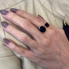 Anel Quartz Glow no banho de Ouro tamanho 18 com Cristal Citrino na tonalidade Conhaque em mãos femininas com esmalte cinza, sobre jaqueta de couro bege