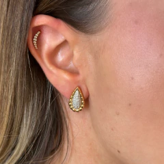 Brinco Gota Duo dourado com detalhes em zircônias cristais usado na orelha de mulher