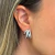 Brinco Ear Cuff Elos Mirage em ródio branco com detalhes em pedras brilhantes, usado na orelha de uma mulher.