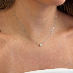 Colar delicado com ponto de luz de moissanite de 5.0MM em corrente de prata usado no pescoço de mulher