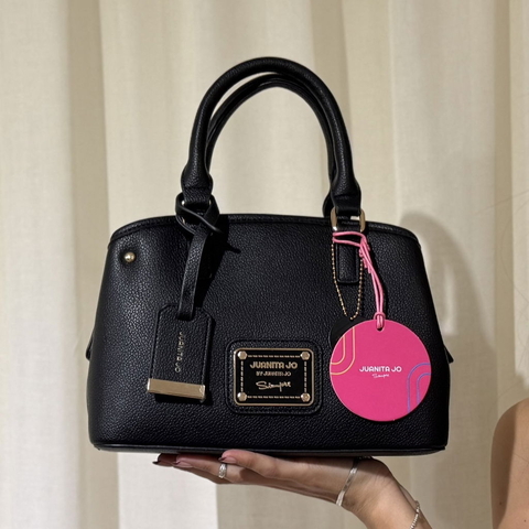 Cartera Venecia Juanita Jo negra de cuero ecológico con correa regulable y cierre superior.
