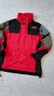 Anorak táctico de The North Face en color rojo y negro, modelo Extrem 90s, con detalles en los hombros y múltiples bolsillos.