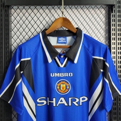 manchester-united-umbro-retro-1996-1997-away-reserva-2-fora-azul-liga-dos-campeoes-champions-league-patrocinios-patrocinadores-patches-patch-torcedor-torcedores-futebol-masculino-masculina-frete-gratis-envio-campeonato-internacional-europa-europeu-europeu