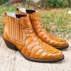 Botina masculina de couro na cor whisky com design escamado, destacando seu formato e detalhes de costura.