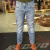 Calça masculina Levis Straight 514 em tom claro, usada com botas marrons, em ambiente interno.