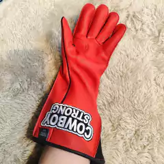 Luva para montaria em touros da marca Cowboy Strong, na cor vermelha, destacando o logotipo na parte externa.