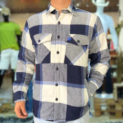 Jaqueta flanelada xadrez azul da marca Thankfield, com detalhes em azul e cinza, apresentando dois bolsos frontais e botão na parte da frente.