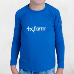 Camiseta infantil térmica UV50+ na cor azul, com logo tx.farm em destaque.