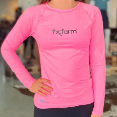 Camiseta UV50+ térmica feminina na cor rosa, com logo tx.farm, ideal para proteção solar.