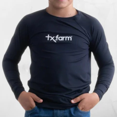 Camiseta infantil UV50+ térmica na cor azul marinho, com logotipo tx.farm, modelo de manga longa.