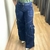 Calça feminina cargo em jeans azul, com bolsos laterais e corte amplo, destacando os detalhes de costura.